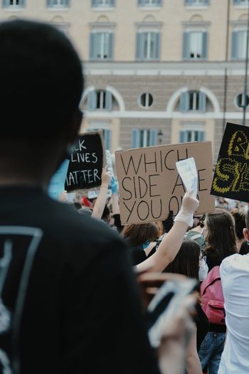 Rear view of people standing against building