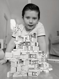 Portrait of boy holding toy on table