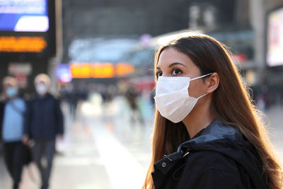 Close-up of beautiful woman wearing mask on street in city