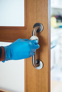 Close-up of hand holding open door