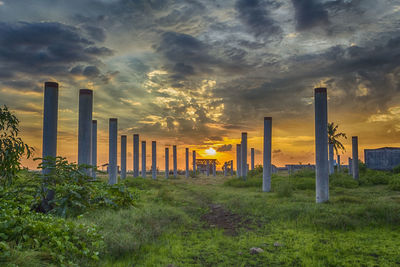 View of field against cloudy sky