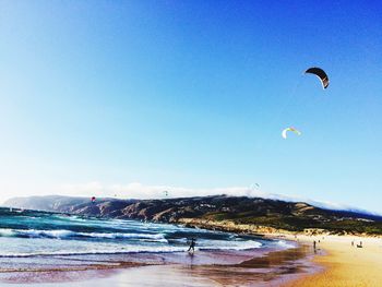 Scenic view of beach against clear blue sky