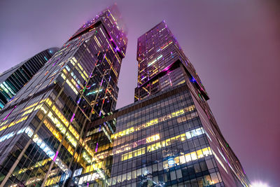 Low angle view of illuminated buildings against sky at night