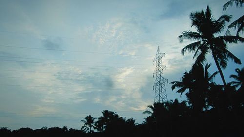 Low angle view of power lines against cloudy sky