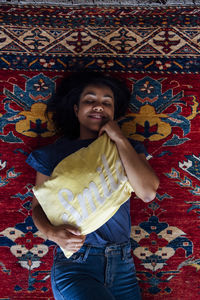 Woman with cushion napping on carpet in living room