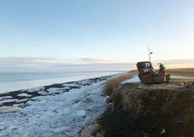 Boat on beach against sky during sunset