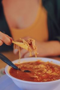 Close-up of woman holding a taco chip 