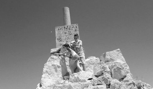 Low angle view of woman standing on rock