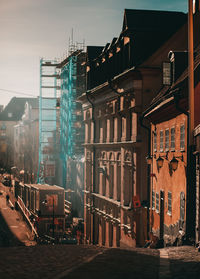 Street by buildings against sky in city