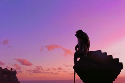 Low angle view of silhouette statue against sky during sunset