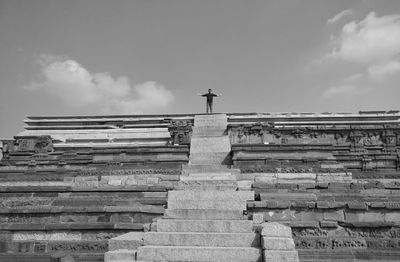 Low angle view of cross against cloudy sky