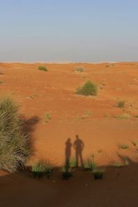 Shadow of two people on sand dune