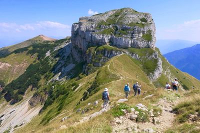 People on mountain against sky