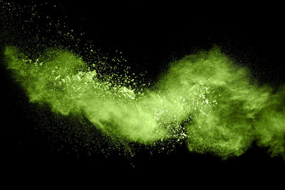 Close-up of powder paint splattering against black background