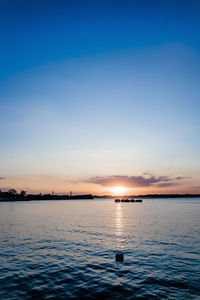 Scenic view of lake against sky at sunset