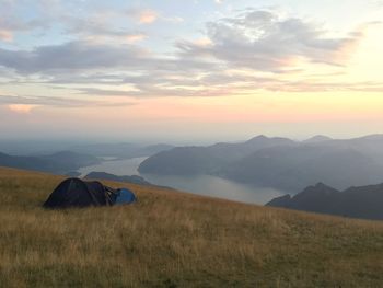 Scenic view of a tent on a field against sky during sunset above iseo lake