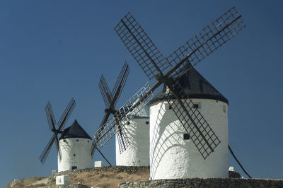 Low angle view of traditional windmill against clear blue sky