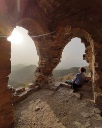 Man sitting at archway enjoy  sunset  and thinking what life go through in watchtower beijing china 