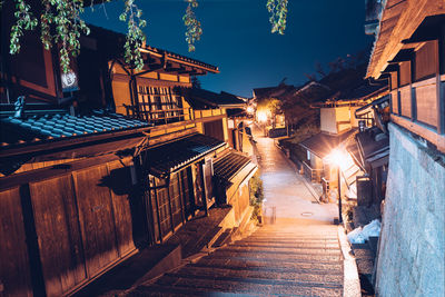 Illuminated street amidst buildings at night