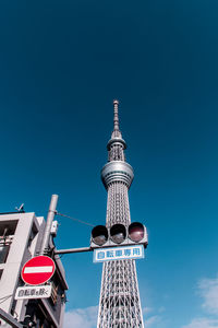 Low angle view of stoplight against tokyo sky tree in city