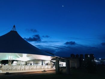 Silhouette buildings against blue sky at night