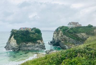 Rock formation on beach against sky