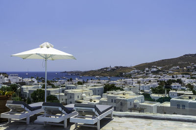 Scenic view of sea and buildings against clear blue sky