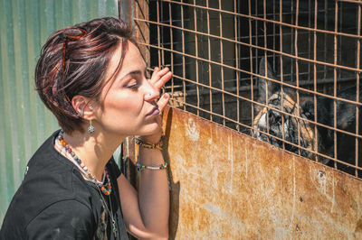 Dog at the shelter.  lonely dogs in cage with cheerful woman volunteer