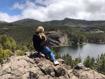 Rear view of man looking at mountain against sky