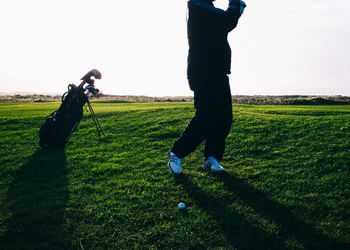 Low section of man standing on golf course