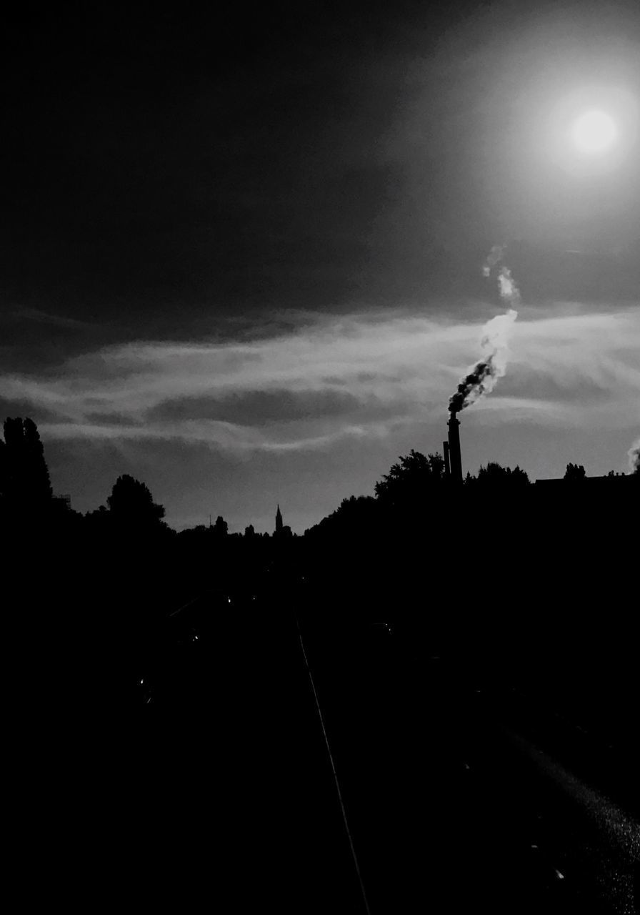 SILHOUETTE SMOKE EMITTING FROM CHIMNEY AGAINST SKY