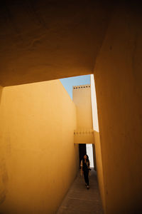 Woman walking in corridor of building