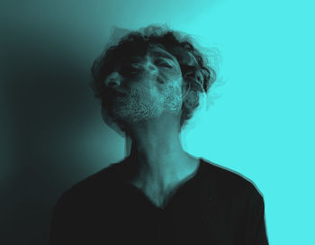 Double exposure of man with face paint against blue background
