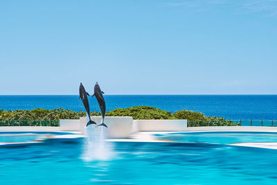 Man in swimming pool against sea