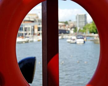 Close-up of red boat against river in city