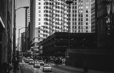 Vehicles on road amidst buildings in city
