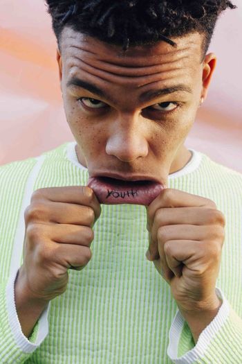 CLOSE-UP PORTRAIT OF YOUNG MAN MAKING FACE