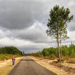 Full length of girl walking roadside against clear sky