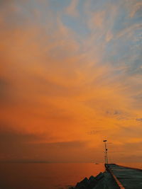 Scenic view of sea against dramatic sky during sunset