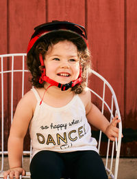 Portrait of a young girl toddler in the backyard wearing a biking helmet