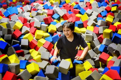 High angle of smiling boy standing in sponge pool