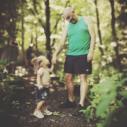 Full length of father and son walking in forest