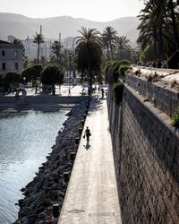 Road by retaining wall against sky in city