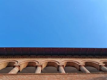 Low angle view of arch against clear blue sky