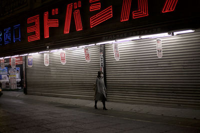 Full length of man standing on illuminated shutter