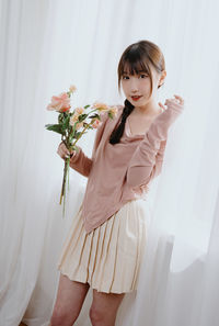 Portrait of young woman with bouquet