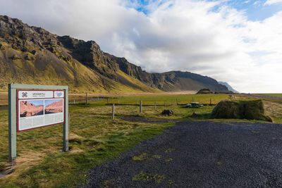 Information sign on mountain against sky