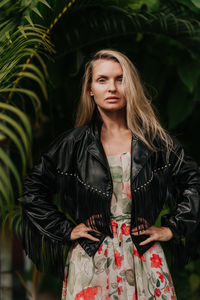 Portrait of young woman standing against plants