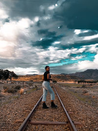 Man standing on railroad track against sky