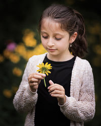 Close-up of girl holding flowering plant
